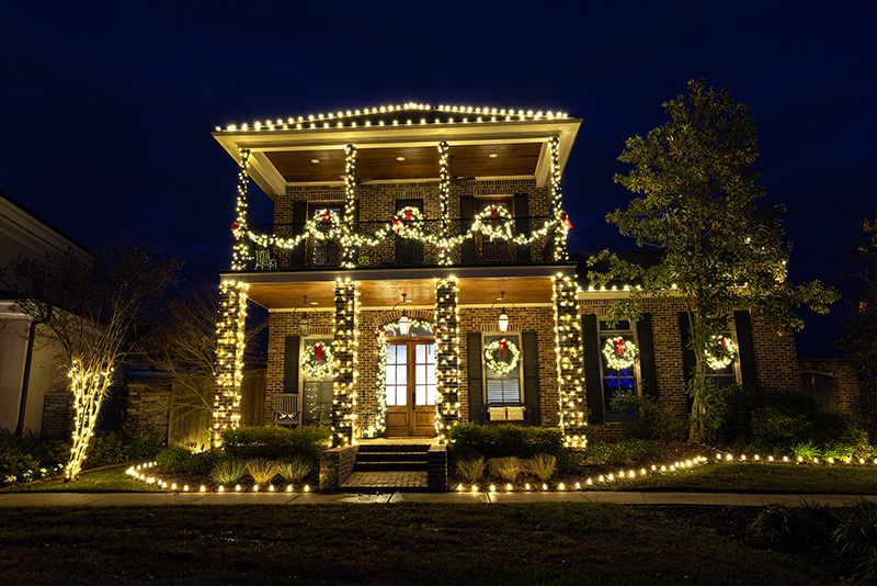 Entryway and bushes lit up with beautiful Christmas lighting display